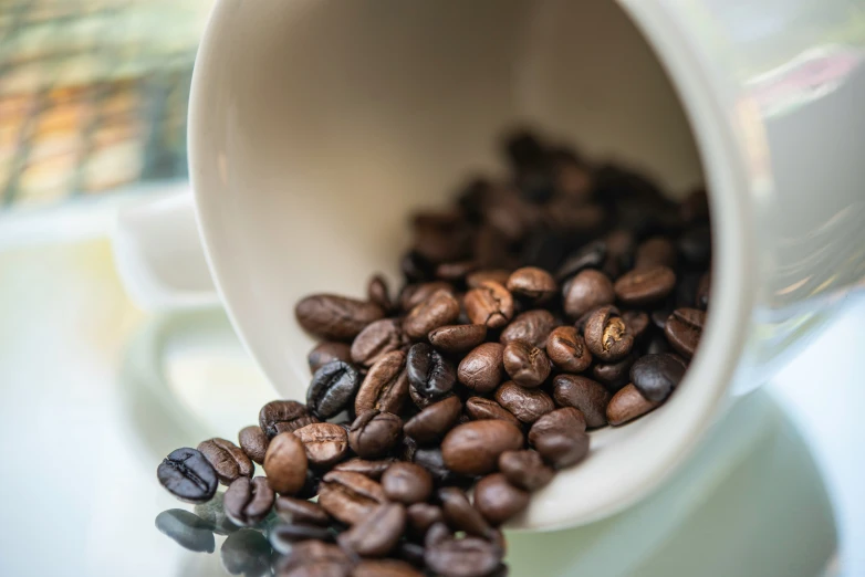 coffee beans fall into the cup which is full