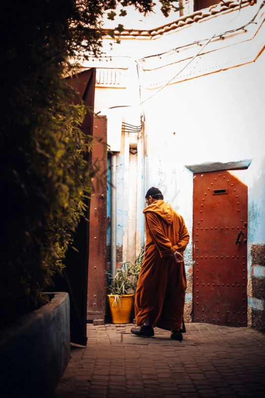 a man in orange robes is standing in the street