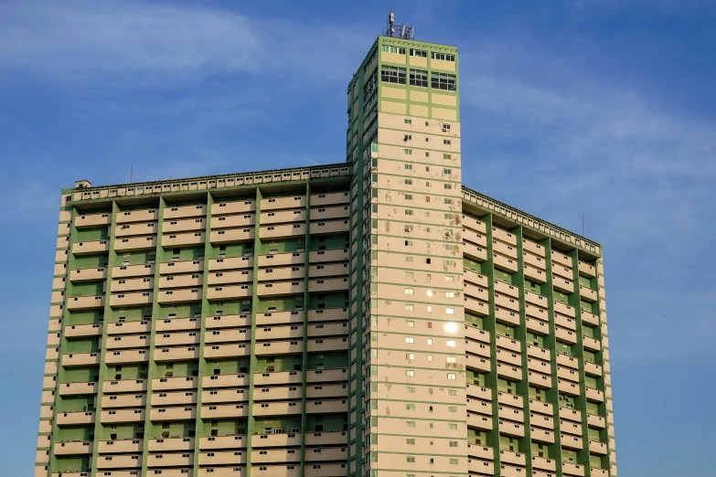 a tall green and tan building sitting next to a traffic light
