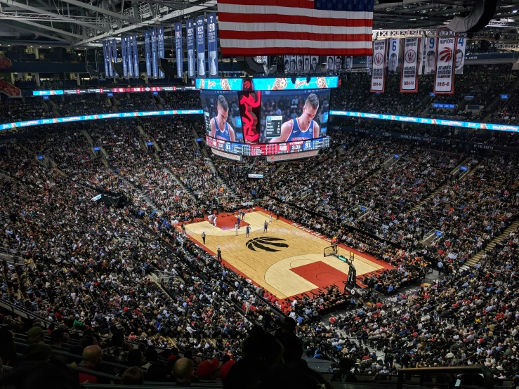 a basketball court full of people and the american flag