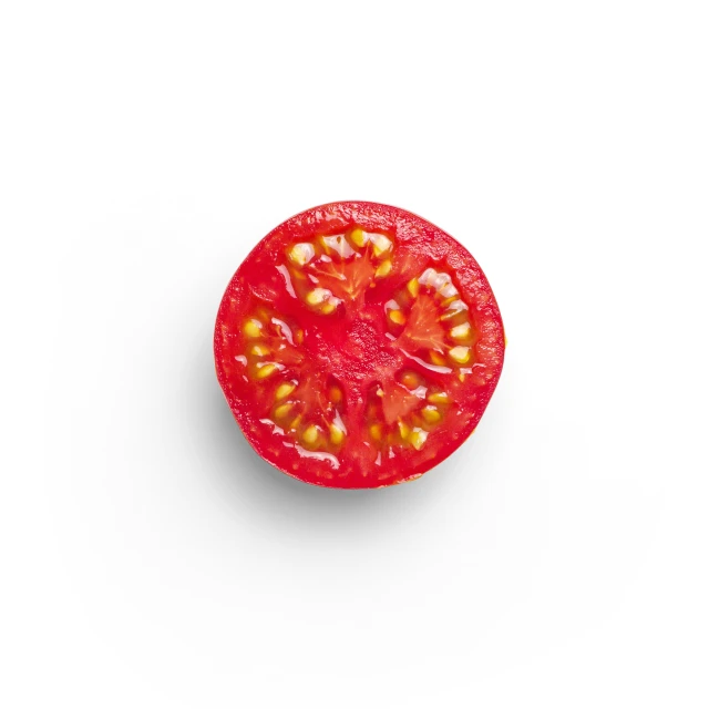 a red tomato on white surface with only one cut in half