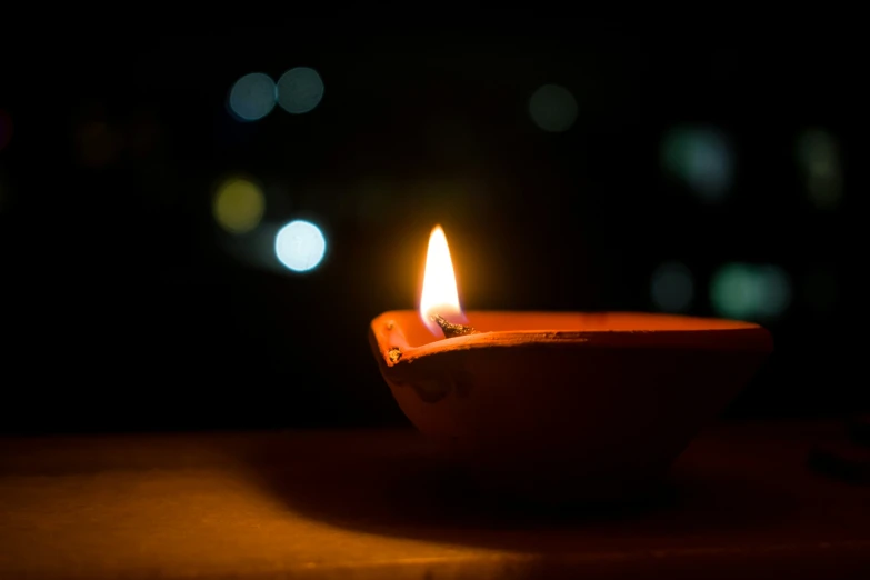 a small lit candle sitting on top of a table