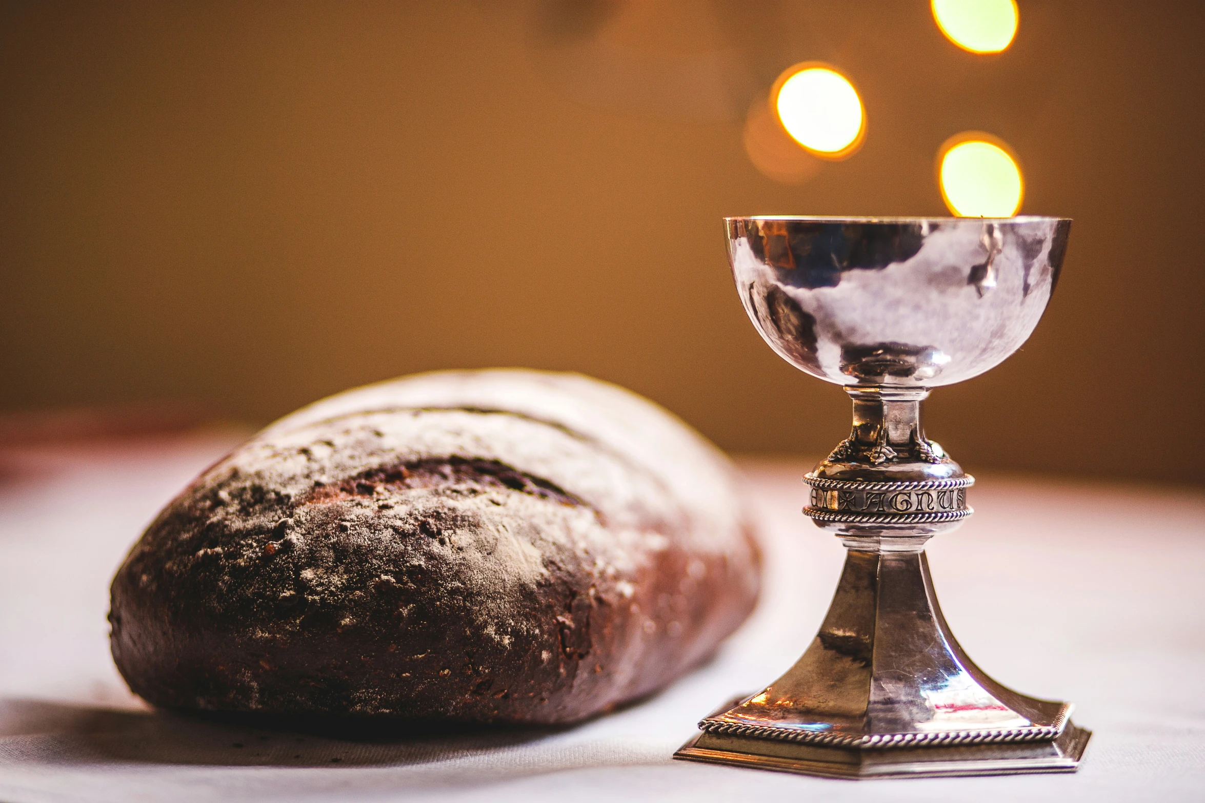 some bread and a small silver goblet on a table