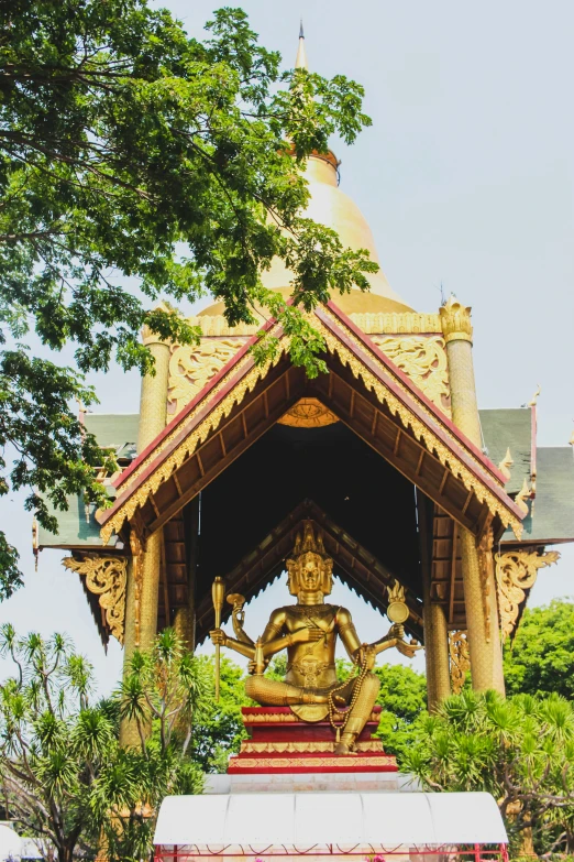 a statue at the end of a shrine under a tree