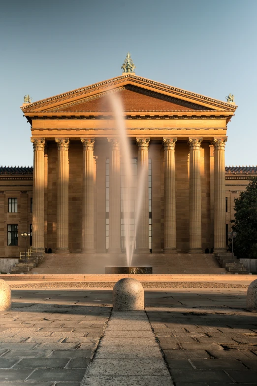 a tall stone building with pillars and columns on the top of it