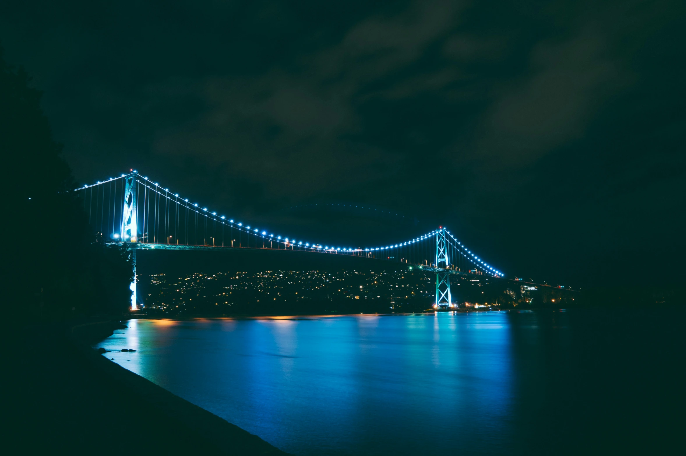 the blue bridge glows brightly in the night sky