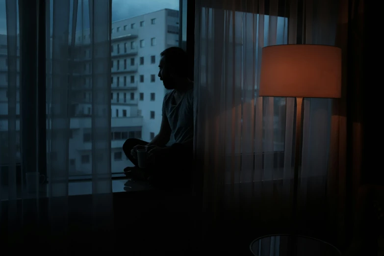 a man sitting on a table in front of a window