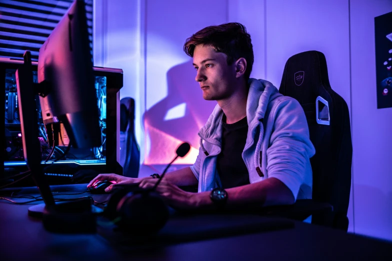 a man sitting in front of a computer at a table with a mouse and keyboard