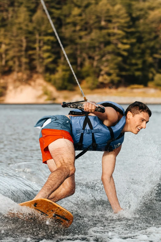 a young man is on the water while holding onto a rope