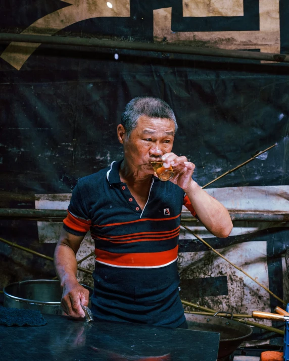 an old man eating a donut while standing next to a giant sign