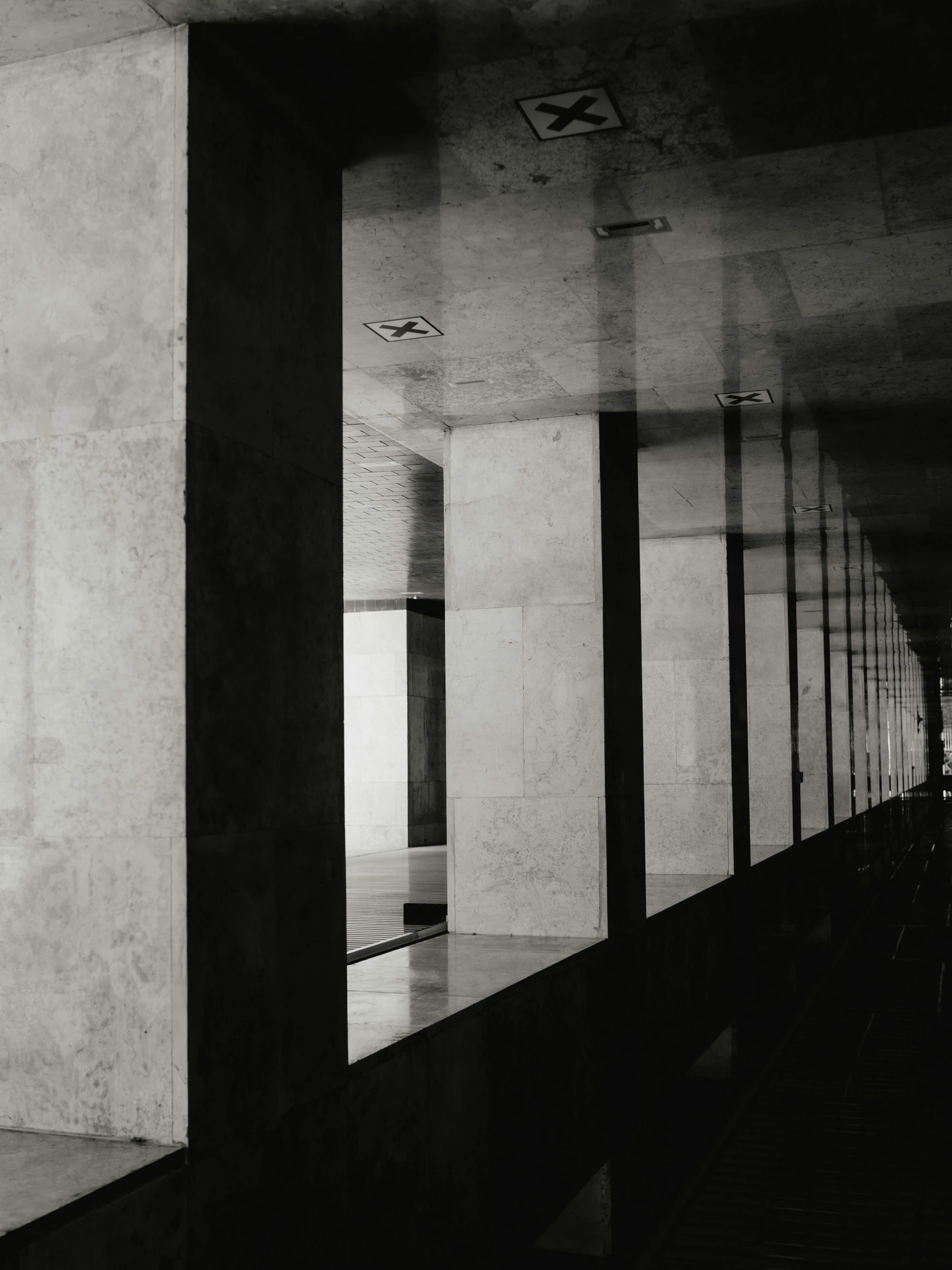 the man is walking down a long, empty walkway