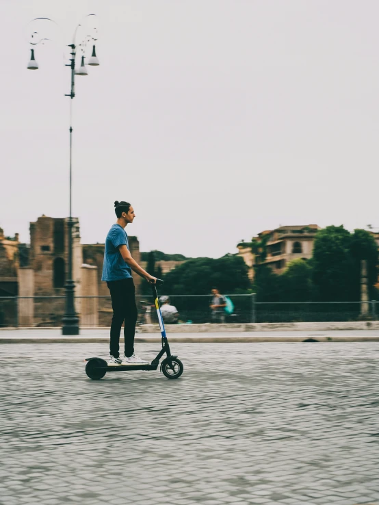 a young man rides his scooter on the street