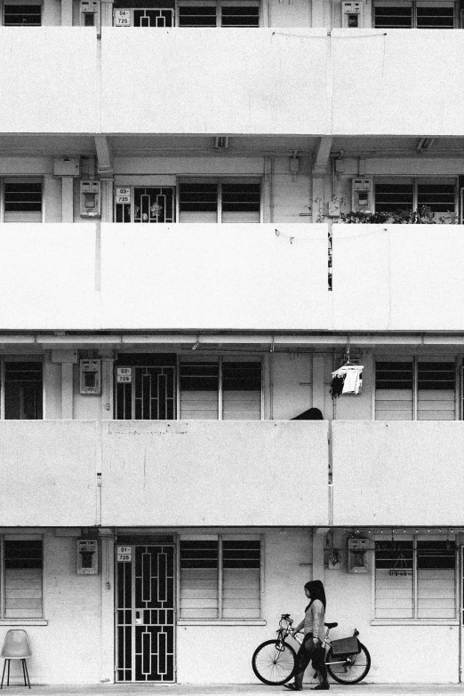 a bike rider is riding past an apartment building