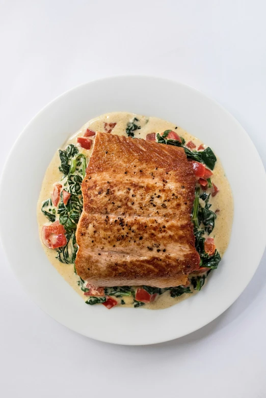 a white plate holding a piece of bread and veggies