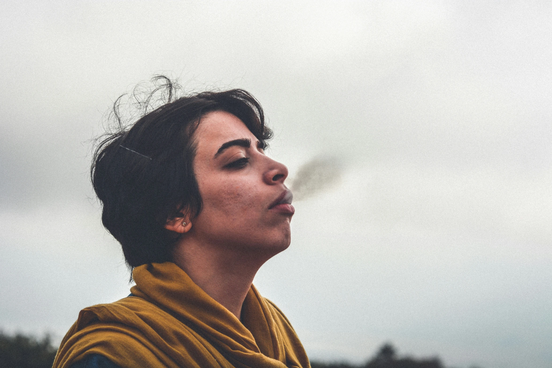 a woman is blowing soap in the wind