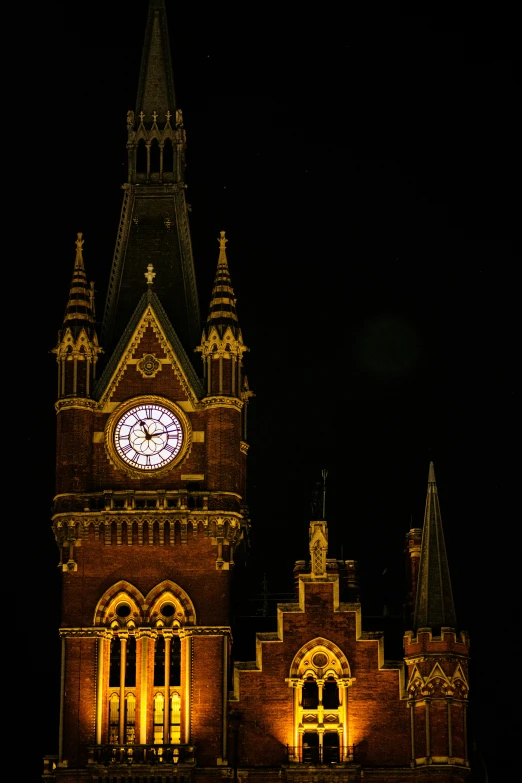 there is a clock tower with an illuminated spire