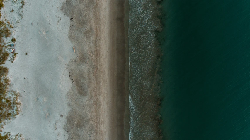 an aerial view of a sandy beach and the ocean