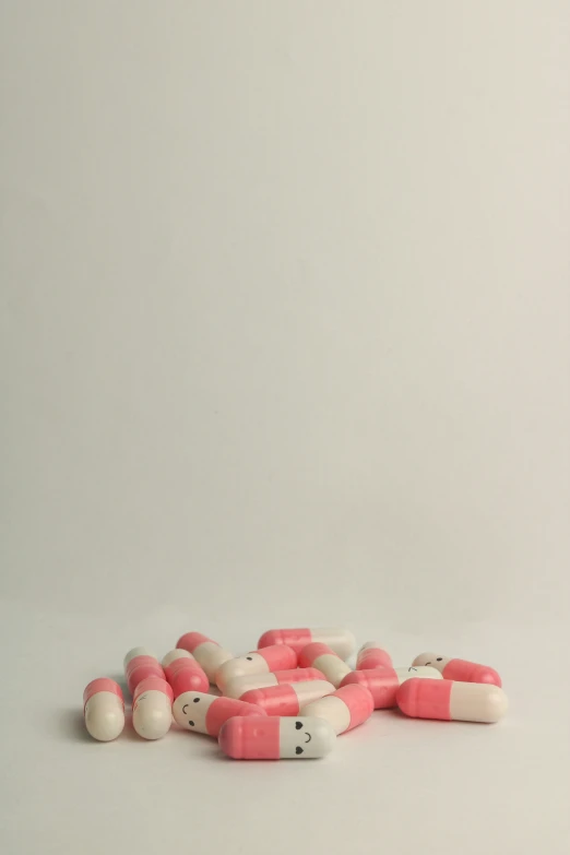 red and white pill pills scattered on top of each other