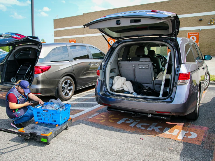 there is a woman who is kneeling down near her car