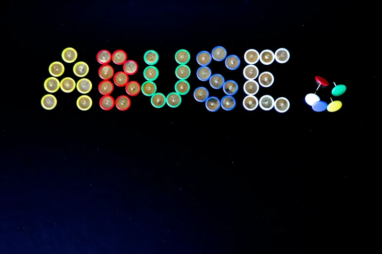 a pograph of different colored lights spelling out on a dark surface