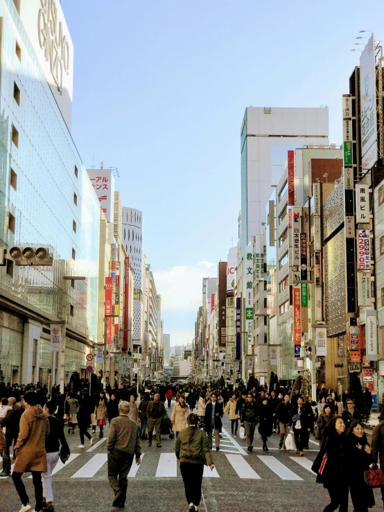 some people are crossing a road and some buildings