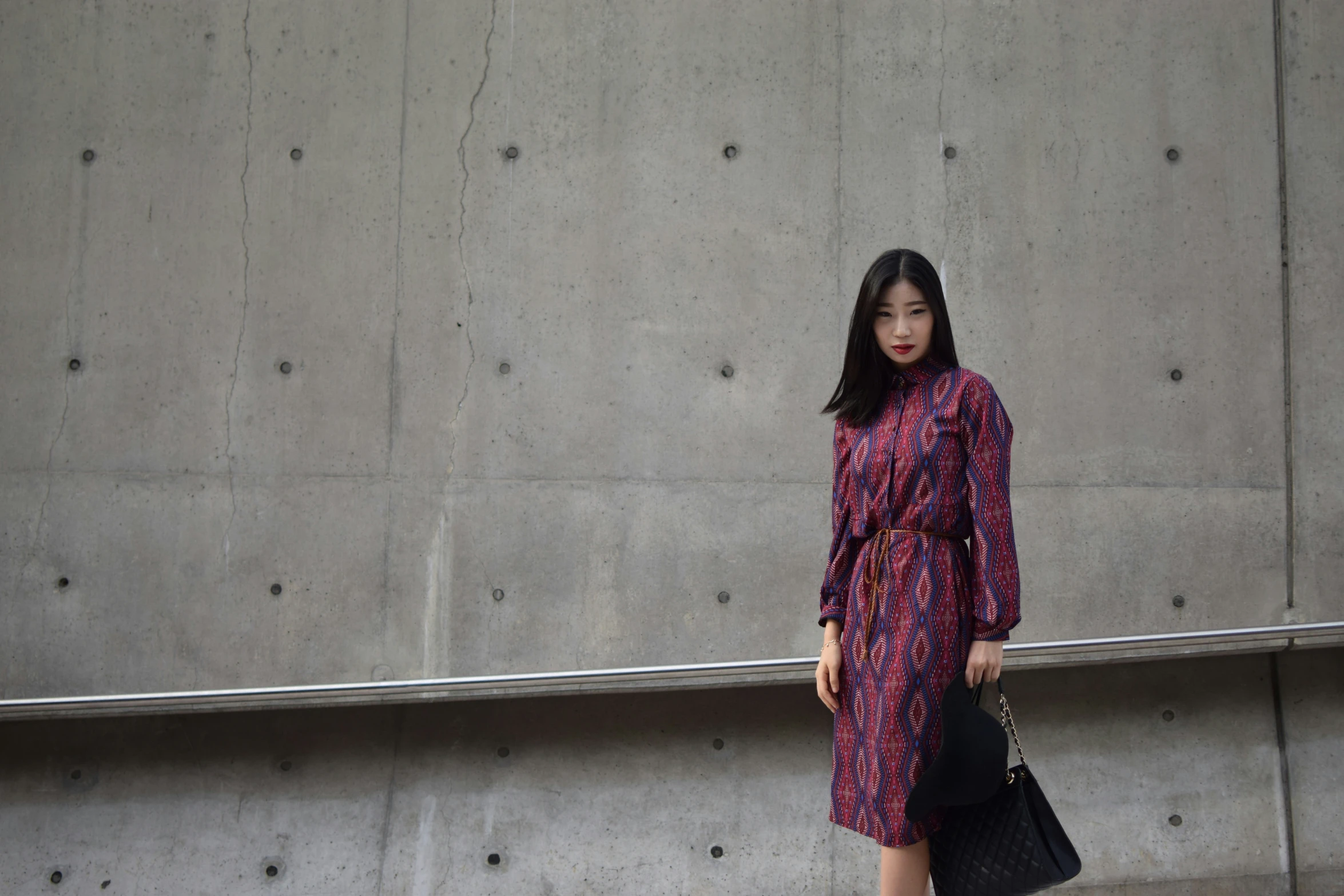 a young woman is walking on the sidewalk