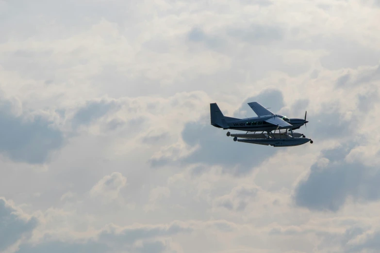 a small plane flies through a cloudy sky