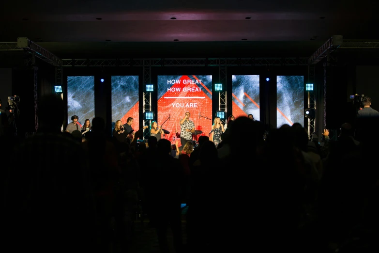 an audience watches a projected presentation at night