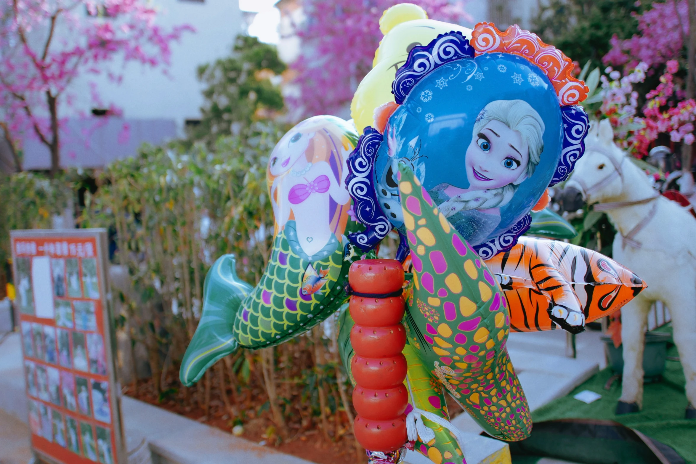 a collection of colorful balloons in a store window