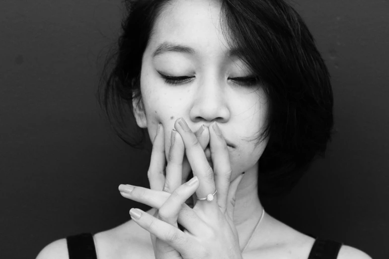 woman covering her face with hands and touching her mouth