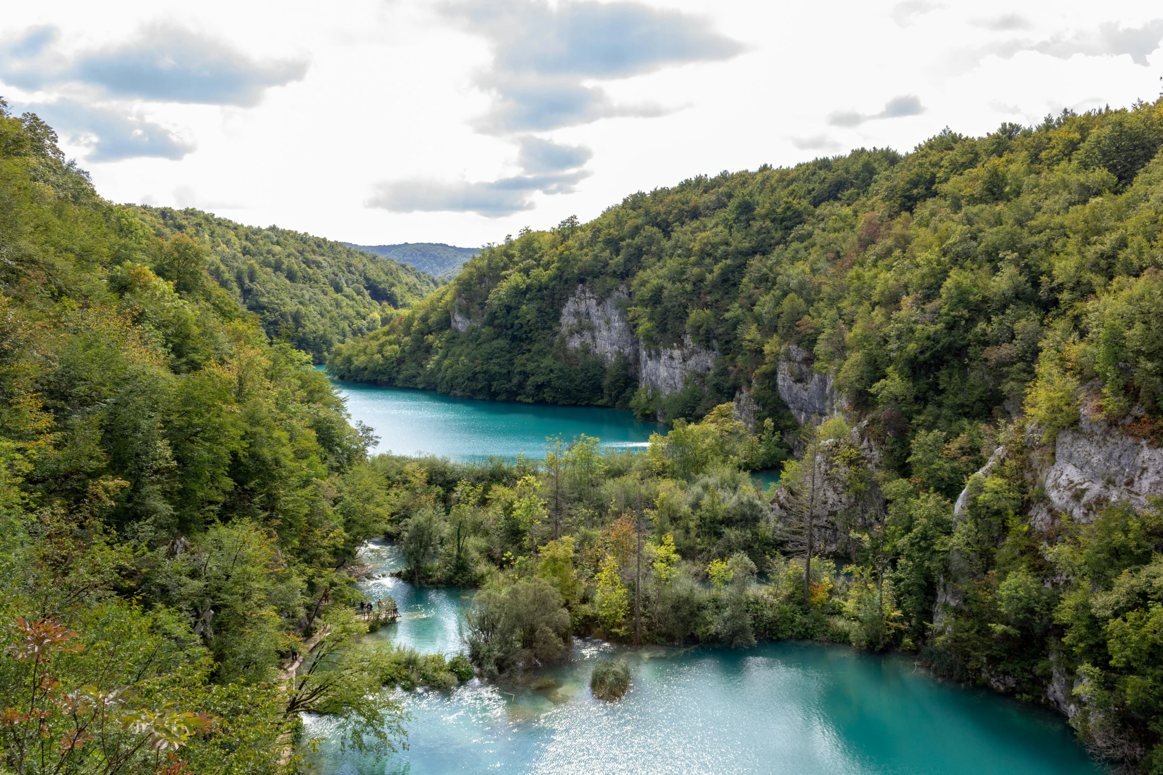 a deep green gorge with blue water surrounded by trees