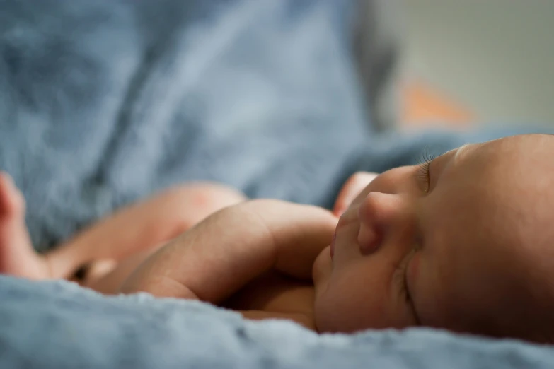 a close up of a baby sleeping on a blanket