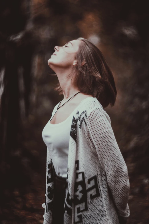 a woman in the woods with a cross pattern on her coat