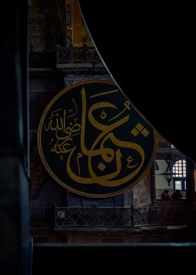 the black and gold arabic writing on an oval sign