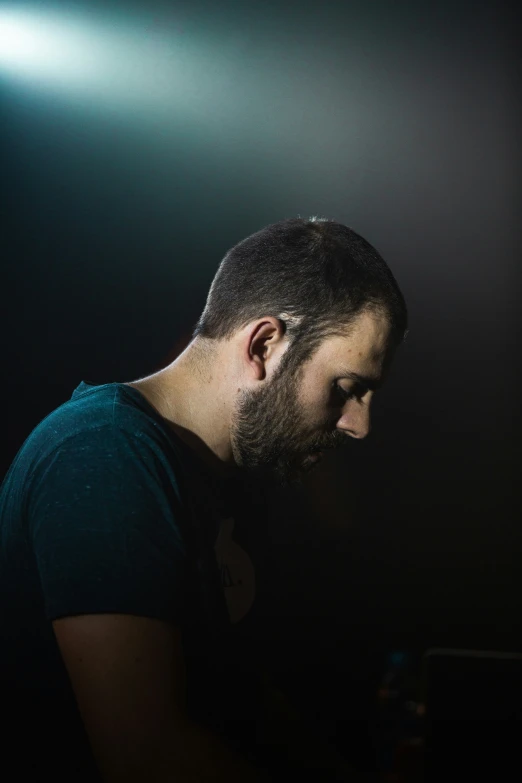 man looking at laptop computer in dark room