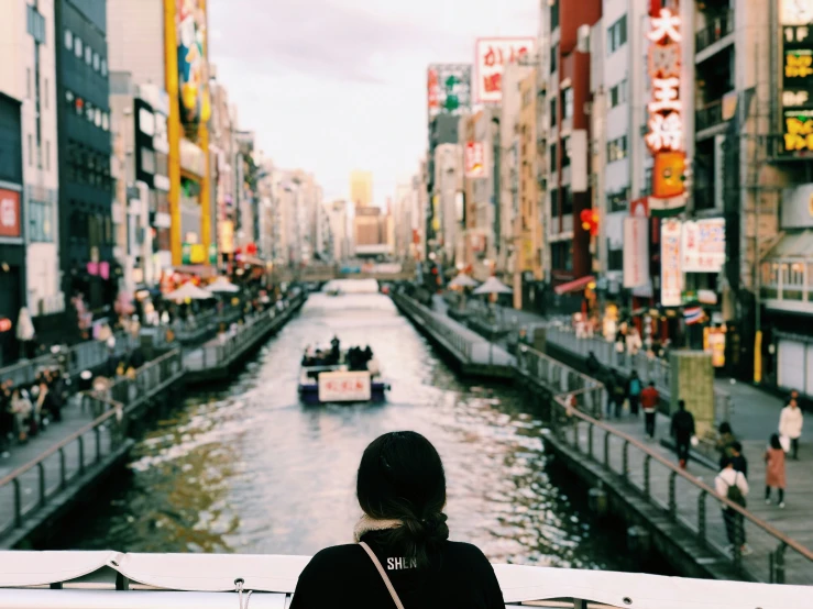 a girl looking down a waterway and boat