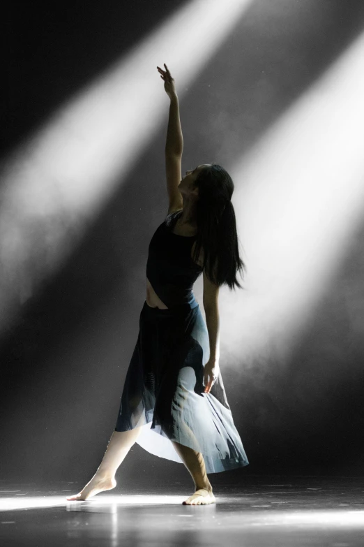 a woman standing in front of a spotlight on a stage