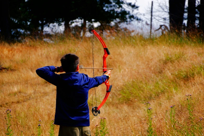 man aiming with bow at soing in the distance