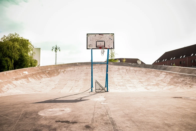 a basketball goal in the middle of a concrete court