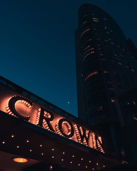 the crown el sign lit up against a blue sky