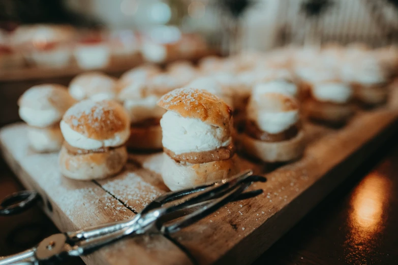 several mini cake and cream cookies on top of a wooden board