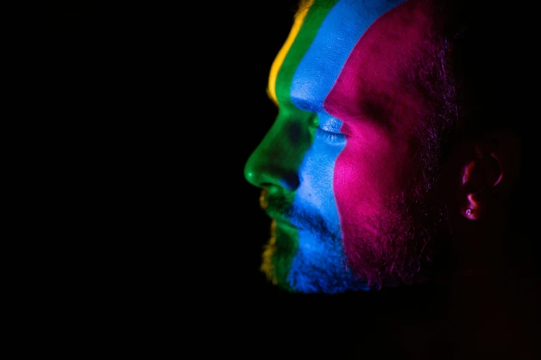 a man with beard and multicolored paint on his face