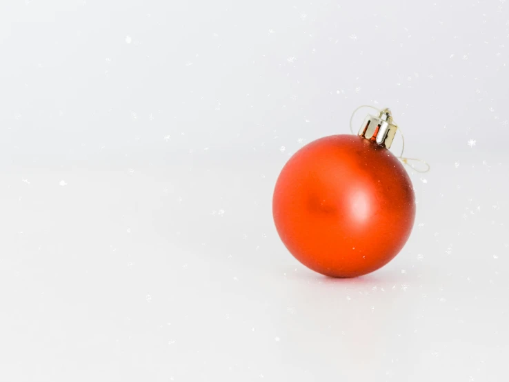 an orange ornament is hanging on a white surface