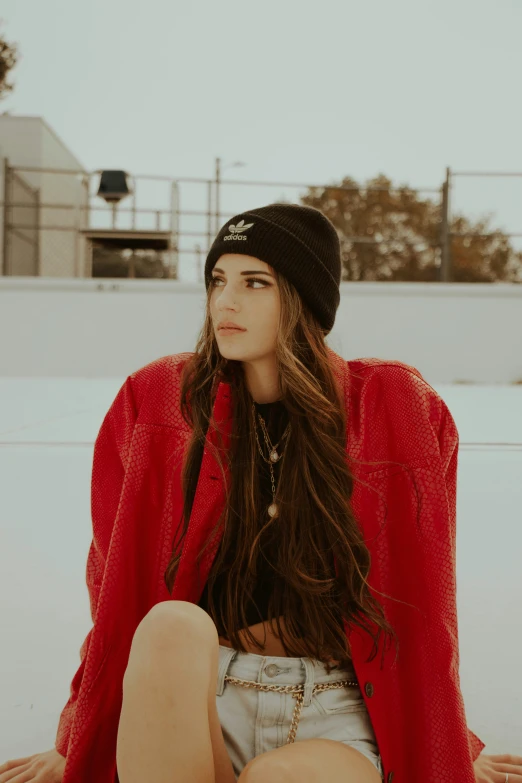 girl wearing winter clothes and a beanie sitting on the floor