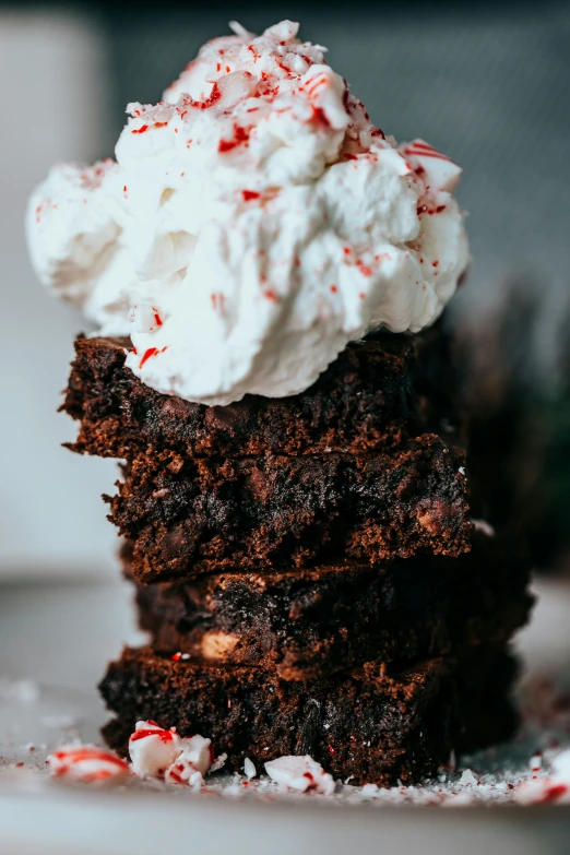 three dessert pieces with whipped cream and peppermink on top