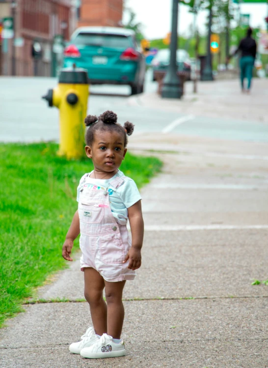 a little girl that is walking down the sidewalk