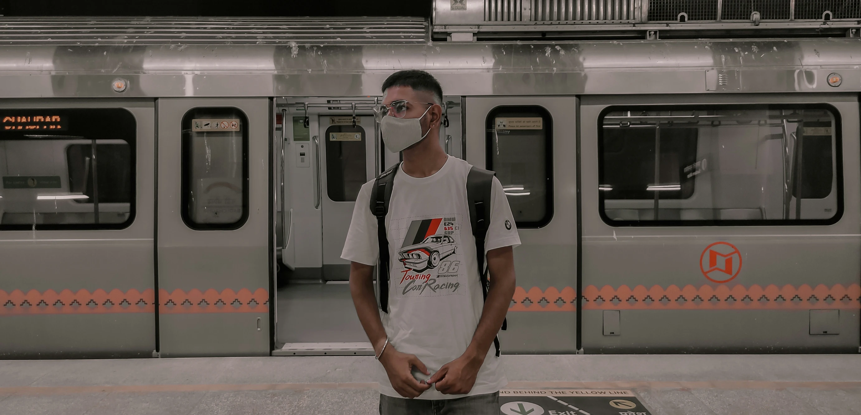 a young man poses next to his bike as a train approaches