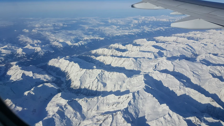 looking out an airplane window at mountains and snow