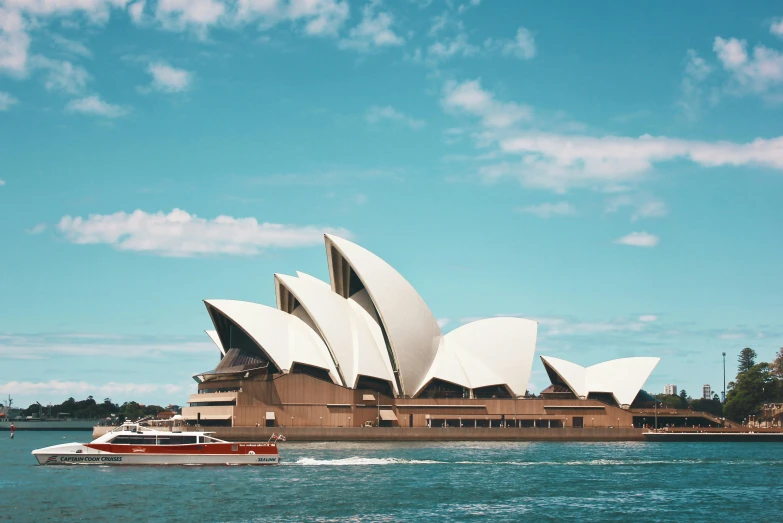 a boat floating in a body of water in front of a large building