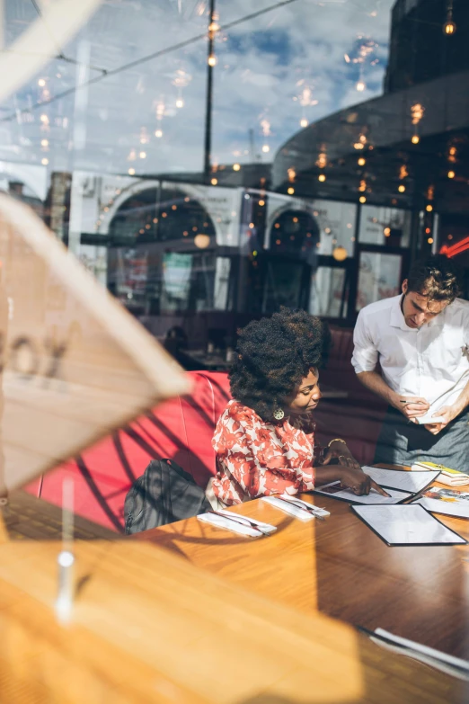 a person sitting at a table with a woman and man next to them